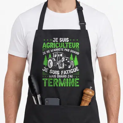 Tablier de cuisine noir avec illustration d'un tracteur vert et texte blanc sur fond sombre.