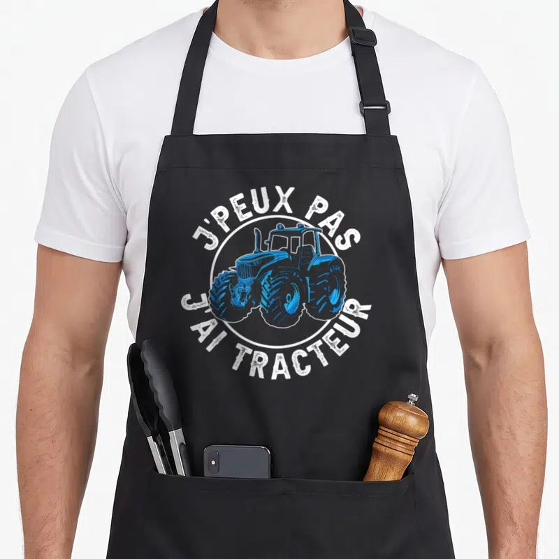 Tablier de cuisine noir avec illustration d'un tracteur bleu et texte blanc Je peux pas j'ai tracteur.
