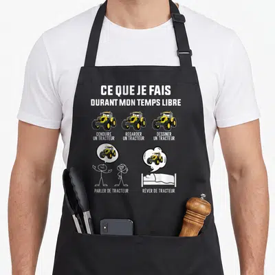 Tablier de cuisine noir avec illustration humoristique sur la passion du tracteur et le temps libre des agriculteurs.