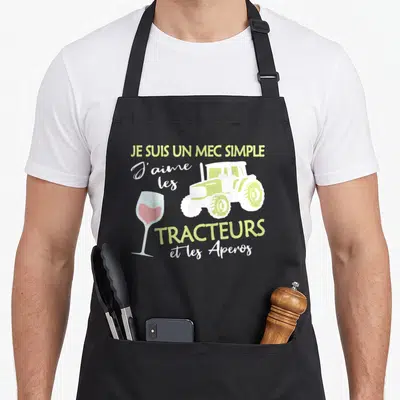 Tablier de cuisine noir avec illustration tracteur vert, verre à vin rose et texte Je suis un mec simple