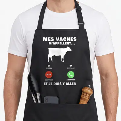 Tablier de cuisine noir avec silhouette blanche de vache et boutons d'appel téléphonique rouge et vert imprimés au centre.
