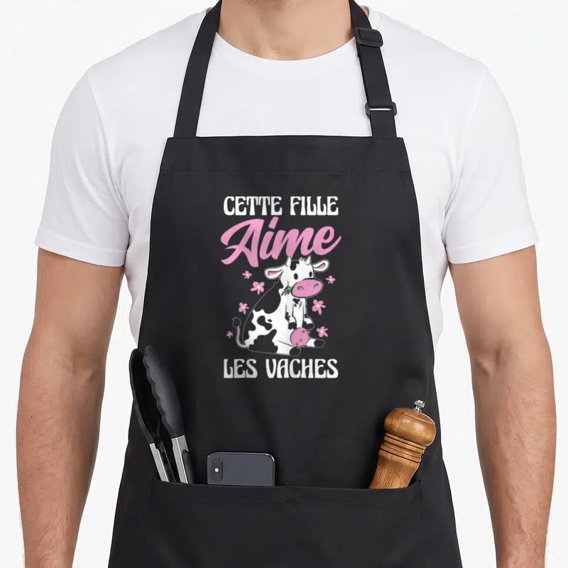 Tablier de cuisine noir avec illustration vache rose et texte Cette Fille Aime Les Vaches en blanc et rose.