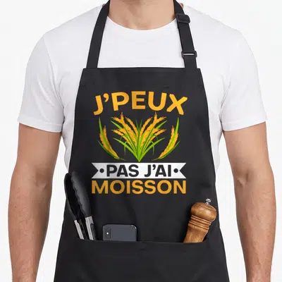 Tablier de cuisine noir avec inscription Je peux pas j'ai moisson et illustration d'épis dorés au centre.