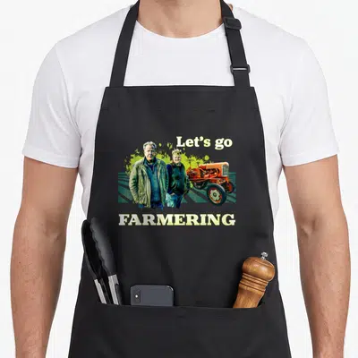 Tablier de cuisine noir avec illustration de deux hommes, d'un tracteur orange et du texte Let's go Farmering en lettres blanches.