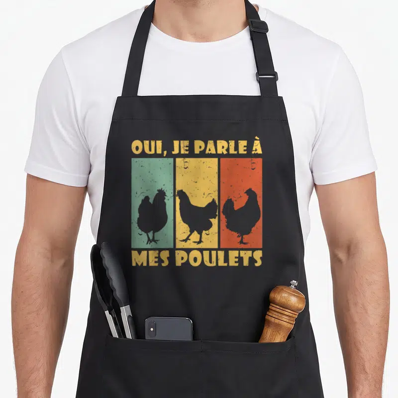 Tablier de cuisine noir avec trois silhouettes de poulets sur fonds vert jaune et orange et texte jaune vintage.