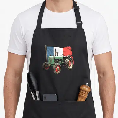 Tablier de cuisine noir avec illustration d'un tracteur vert portant un drapeau français sur une perche en bois.