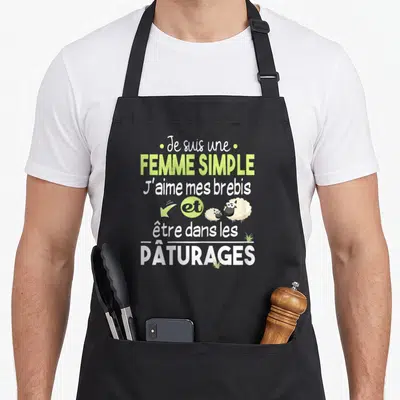 Tablier de cuisine noir avec texte Je suis une femme simple j'aime mes brebis et être dans les pâturages illustré d'un mouton.