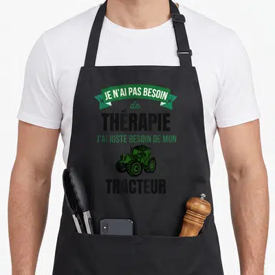 Tablier de cuisine noir avec l'inscription Je n'ai pas besoin de thérapie et un tracteur vert imprimé au centre.