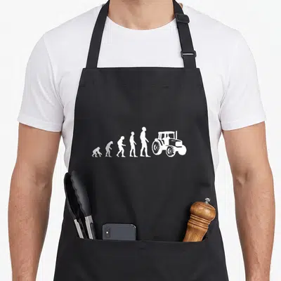 Tablier de cuisine noir avec silhouette blanche évoluant vers un tracteur agricole stylisé.