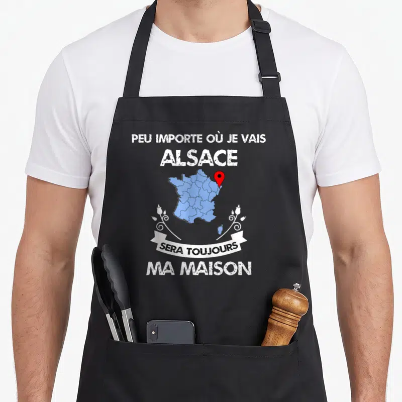 Tablier de cuisine noir avec une carte de France bleue, un repère rouge et le texte blanc peu importe où je vais alsace sera toujours ma maison.