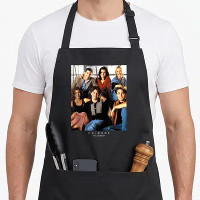 Tablier de cuisine noir avec une photo de groupe de six personnages souriants et le texte Friends The TV Series imprimé en blanc.