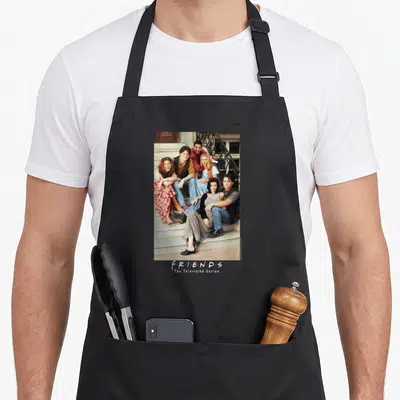 Tablier de cuisine noir avec photo de six amis assis sur un escalier et le titre de la série imprimé en bas.
