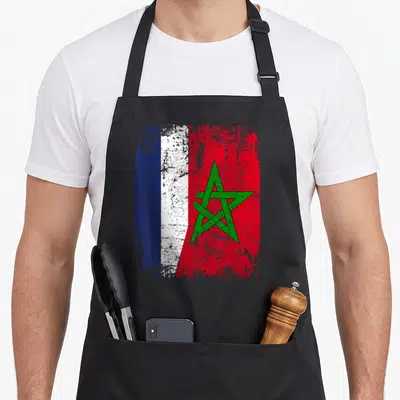 Tablier de cuisine noir avec un drapeau stylisé marocain et français portant une étoile verte centrale.