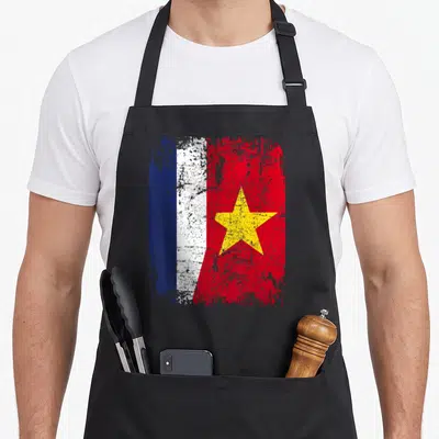 Tablier de cuisine noir avec un motif de drapeau combinant les couleurs françaises et vietnamiennes en style dégradé.