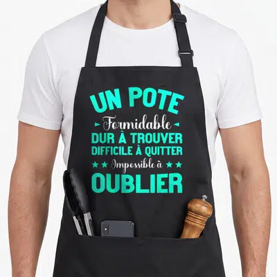 Tablier de cuisine noir avec typographie turquoise et blanche proclamant un pote formidable difficile à oublier.