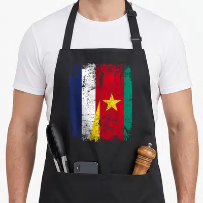 Tablier de cuisine noir avec un drapeau combinant les couleurs du Cameroun et de la France en style vieilli.