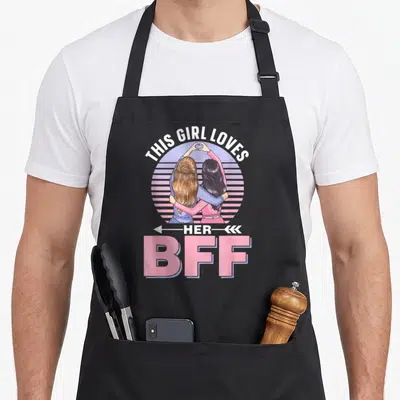 Tablier de cuisine noir avec illustration de deux amies se serrant dans leurs bras au-dessus du texte BFF en lettres roses.