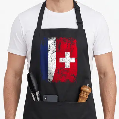 Tablier de cuisine noir avec un drapeau fusionnant les bandes bleue blanche rouge française et la croix blanche sur fond suisse.