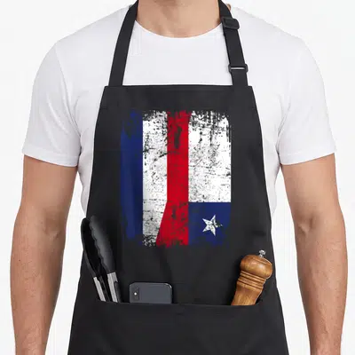 Tablier de cuisine noir avec un drapeau stylisé combinant les couleurs de la France et du Chili sur fond texturé.