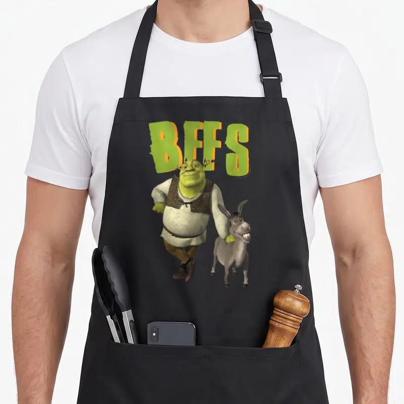 Tablier de cuisine noir avec Shrek, Donkey et l'inscription BFFS en lettres vertes et orange.