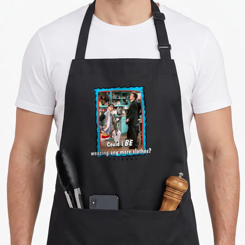 Tablier de cuisine noir avec une scène de Friends et le texte Could I BE wearing any more clothes.