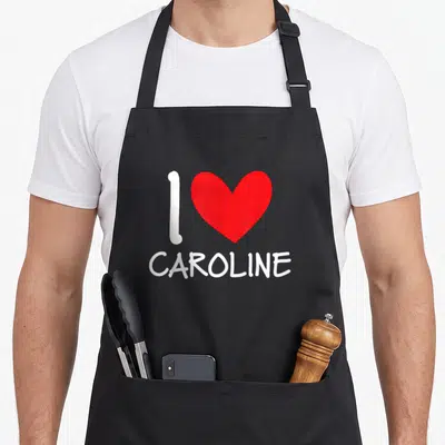 Tablier de cuisine noir avec un grand cœur rouge et le texte blanc I Love Caroline imprimé au centre.