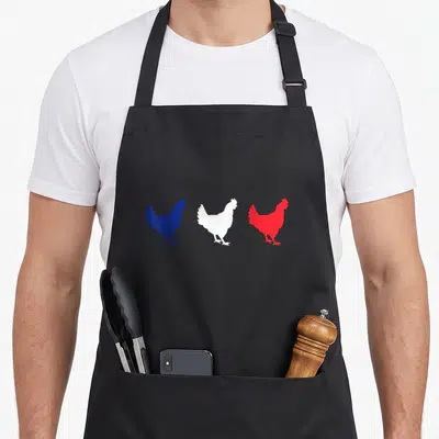 Tablier de cuisine noir avec trois silhouettes de coqs bleus blancs et rouges alignées horizontalement.