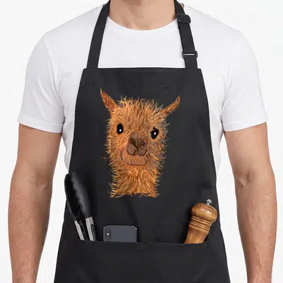 Tablier de cuisine noir avec tête d'alpaga aux cheveux longs et regard doux imprimé au centre.