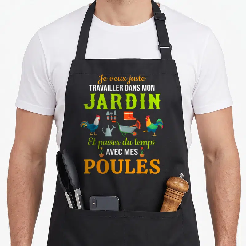 Tablier de cuisine noir avec inscription Travailler dans mon jardin et illustration de poules, brouette et outils de jardinage.