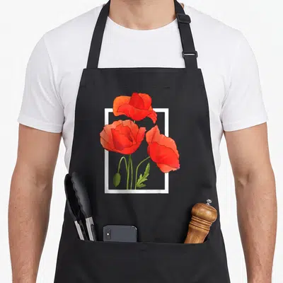 Tablier de cuisine noir avec illustration de trois coquelicots rouges aquarellisés encadrés de blanc sur fond uni.