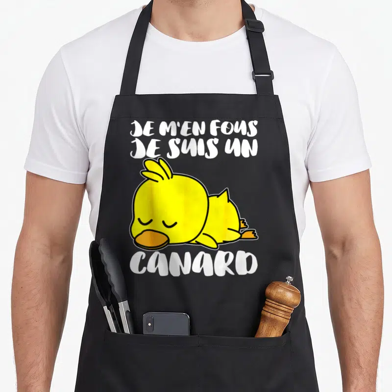 Tablier de cuisine noir avec un canard jaune dormant et l'inscription Je m'en fous je suis un canard en lettres blanches.