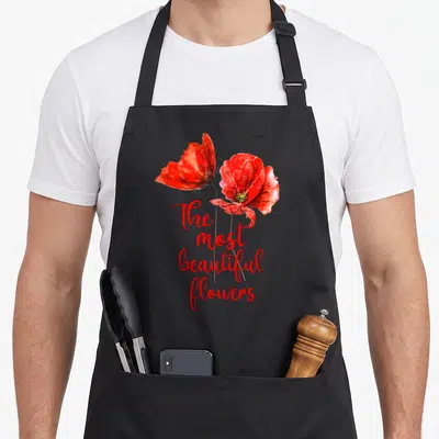Tablier de cuisine noir avec deux coquelicots rouges peints et le texte « The most beautiful flowers » en calligraphie rouge.