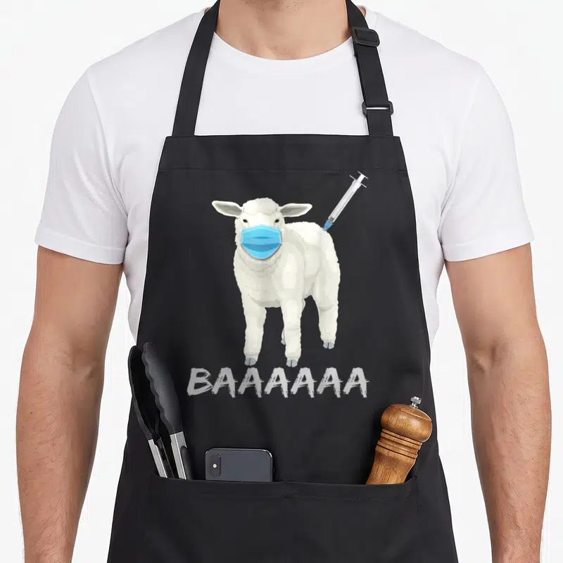 Tablier de cuisine noir avec illustration d'un mouton au masque bleu, une seringue dans le dos et l'inscription BAAAAAA en bas.