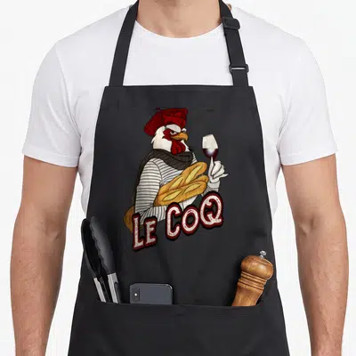 Tablier de cuisine noir avec un coq portant béret, tenant une baguette et un verre de vin rouge.