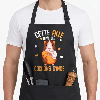 Tablier de cuisine noir avec illustration d'un cochon d'inde en pull orange formant un cœur avec les pattes.