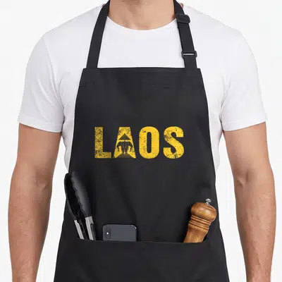 Tablier de cuisine noir avec l'inscription LAOS jaune contenant un éléphant et une pagode stylisée dans la lettre A.