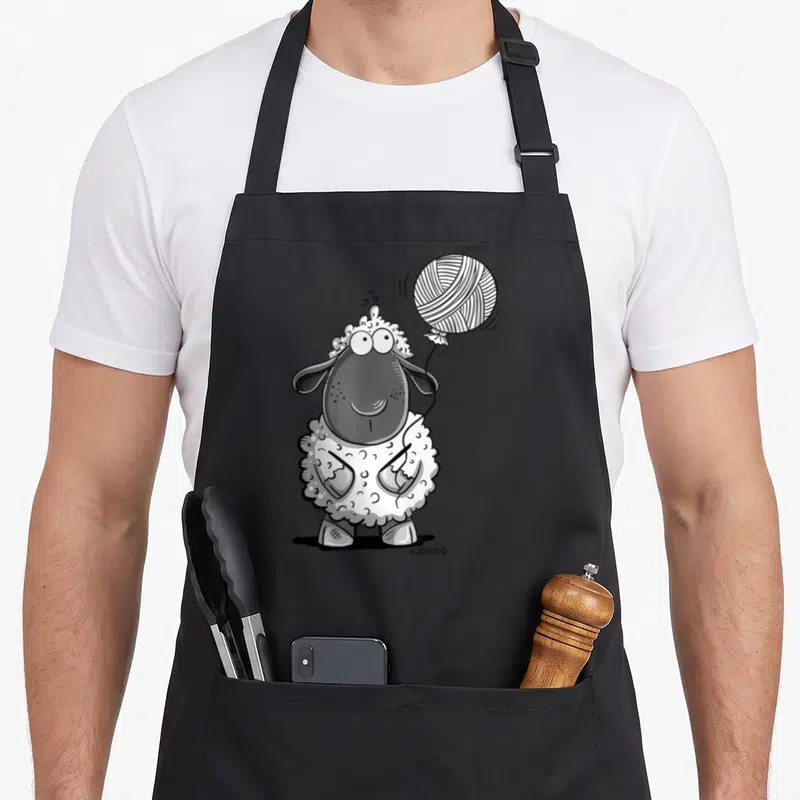 Tablier de cuisine noir avec illustration d'un mouton mignon aux yeux ronds tenant un ballon en laine, style dessin animé noir et blanc.
