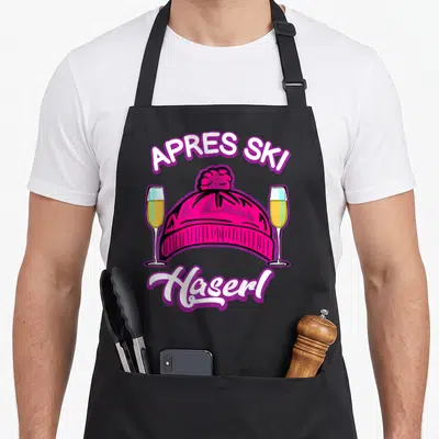 Tablier de cuisine noir avec bonnet rose, deux flûtes de champagne et le texte Après Ski Haserl imprimé en blanc et violet.