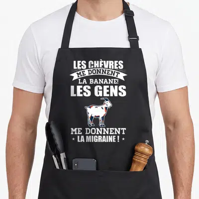Tablier de cuisine noir avec illustration de chèvre et texte blanc Les Chèvres me donnent la banane les gens me donnent la migraine
