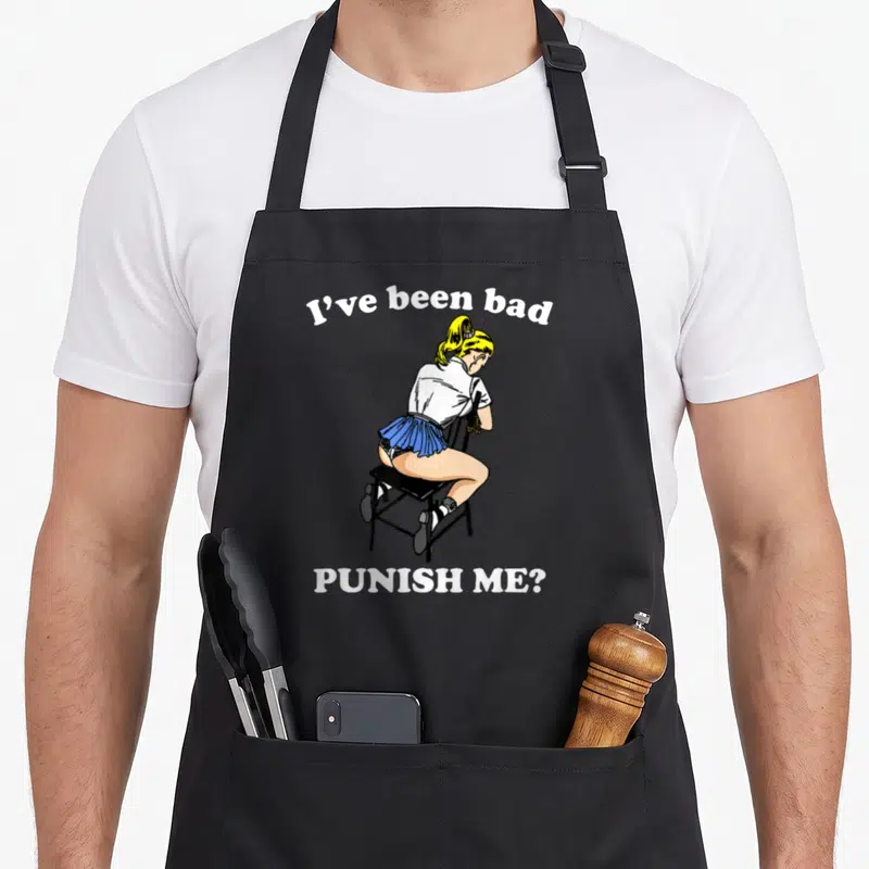Tablier de cuisine noir avec illustration d'une blonde en jupe plissée bleue et texte blanc I've been bad PUNISH ME?