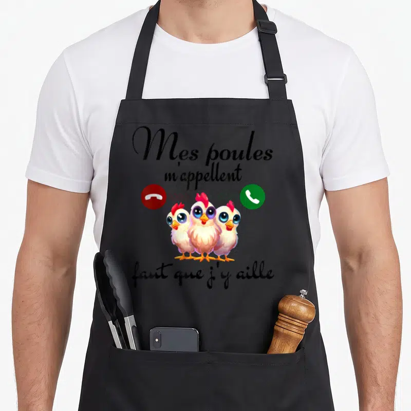 Tablier de cuisine noir avec trois poussins colorés et une inscription humoristique sur les poules.