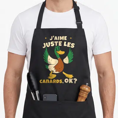 Tablier de cuisine noir avec un canard aux ailes vertes et le texte J'aime juste les canards, ok ?