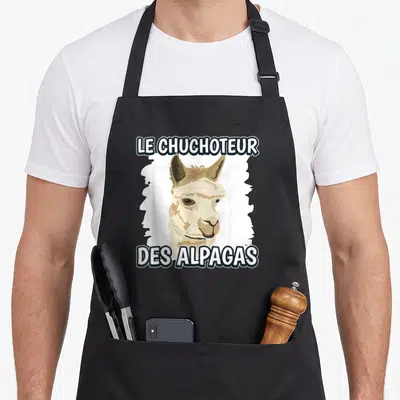 Tablier de cuisine noir avec illustration d'alpaga beige et texte blanc Le Chuchoteur des Alpagas.