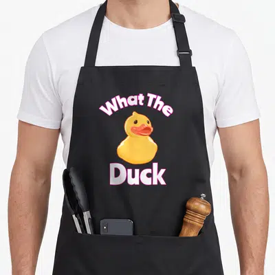 Tablier de cuisine noir avec illustration d'un canard jaune et texte What The Duck en blanc et rose.