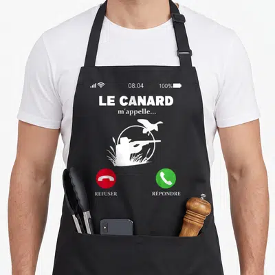 Tablier de cuisine noir avec illustration d'un appel téléphonique montrant un chasseur et le texte Le canard m'appelle.