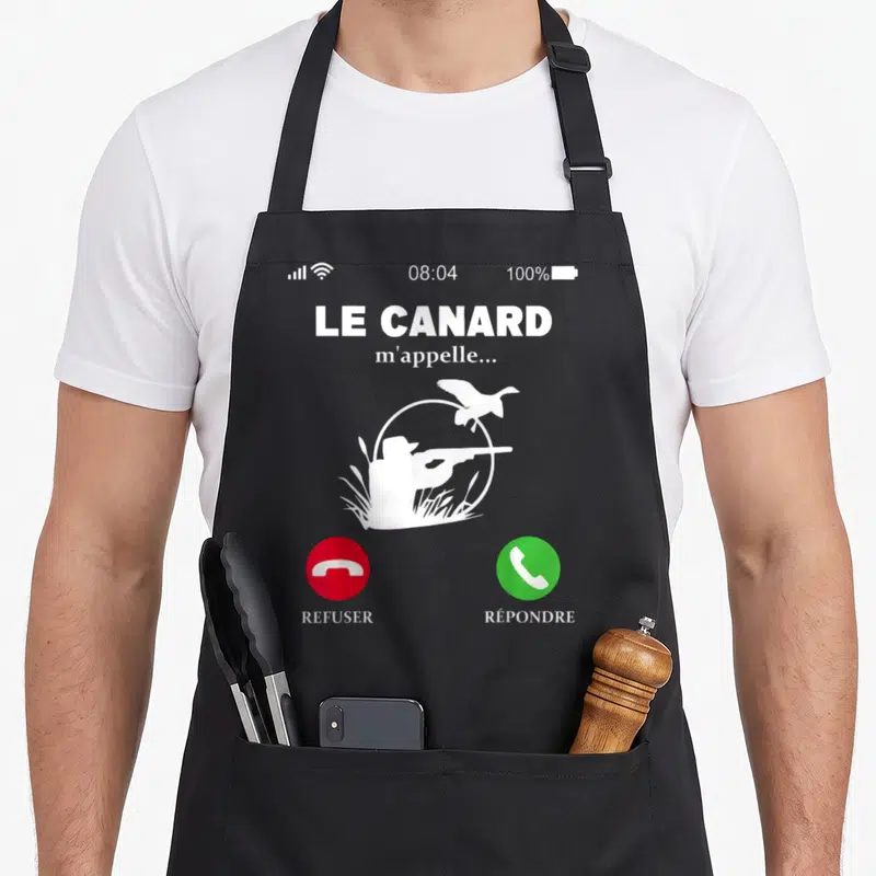 Tablier de cuisine noir avec illustration d'un appel téléphonique montrant un chasseur et le texte Le canard m'appelle.