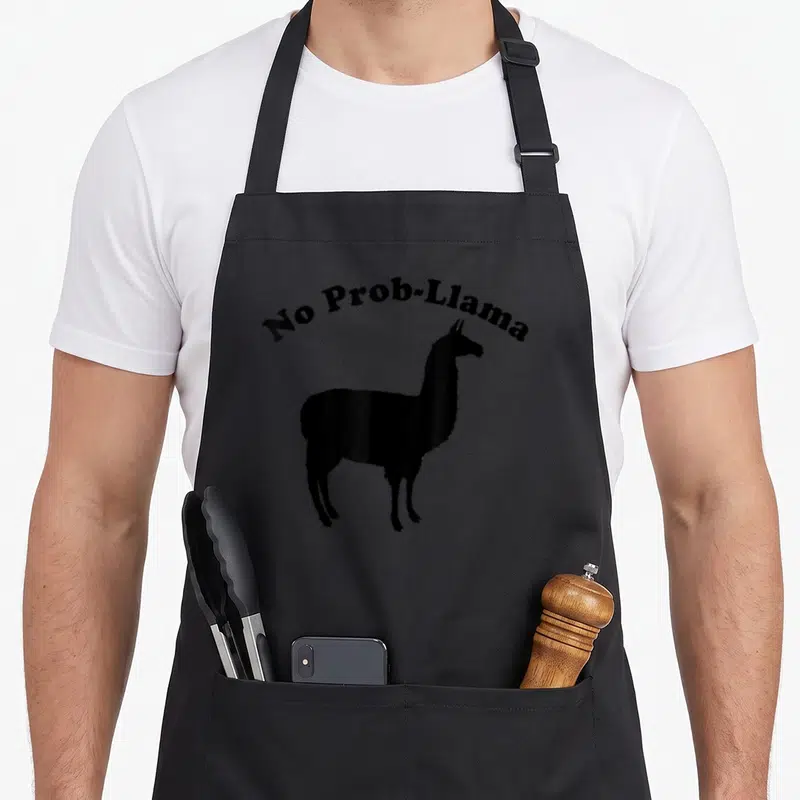 Tablier de cuisine noir orné d'un lama noir stylisé et du texte No Prob-Llama en arc de cercle.