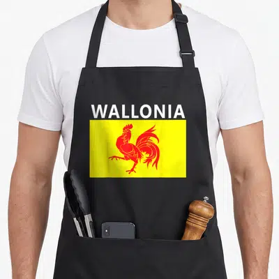 Tablier de cuisine noir avec le drapeau wallon jaune, un coq rouge stylisé et le mot Wallonia en blanc au-dessus.