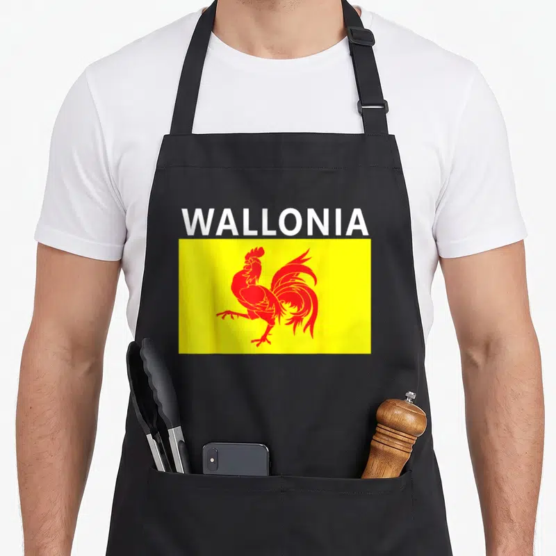 Tablier de cuisine noir avec le drapeau wallon jaune, un coq rouge stylisé et le mot Wallonia en blanc au-dessus.