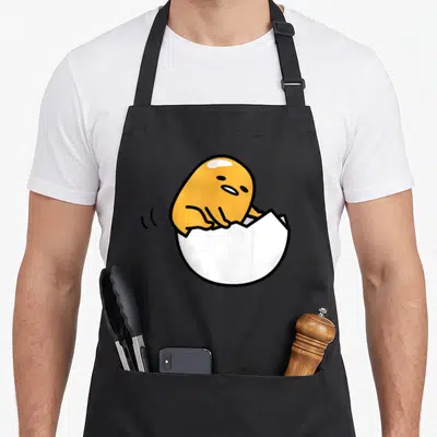 Tablier de cuisine noir avec un jaune dans une coquille blanche cassée et des traits noirs minimalistes.